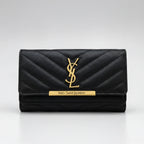 A navy blue quilted leather wallet by Yves Saint Laurent, featuring a gold-tone YSL monogram logo and a gold-tone brand plaque on the front flap, set against a neutral gray background.