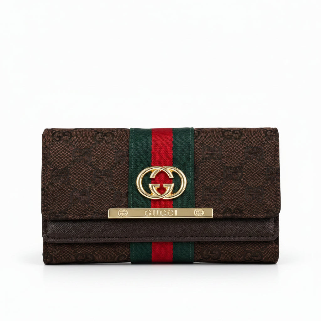 Gucci monogram canvas wallet in dark brown with a green and red web stripe, gold-tone interlocking G logo, and a gold-tone metal bar engraved with 'GUCCI' on a white background.
