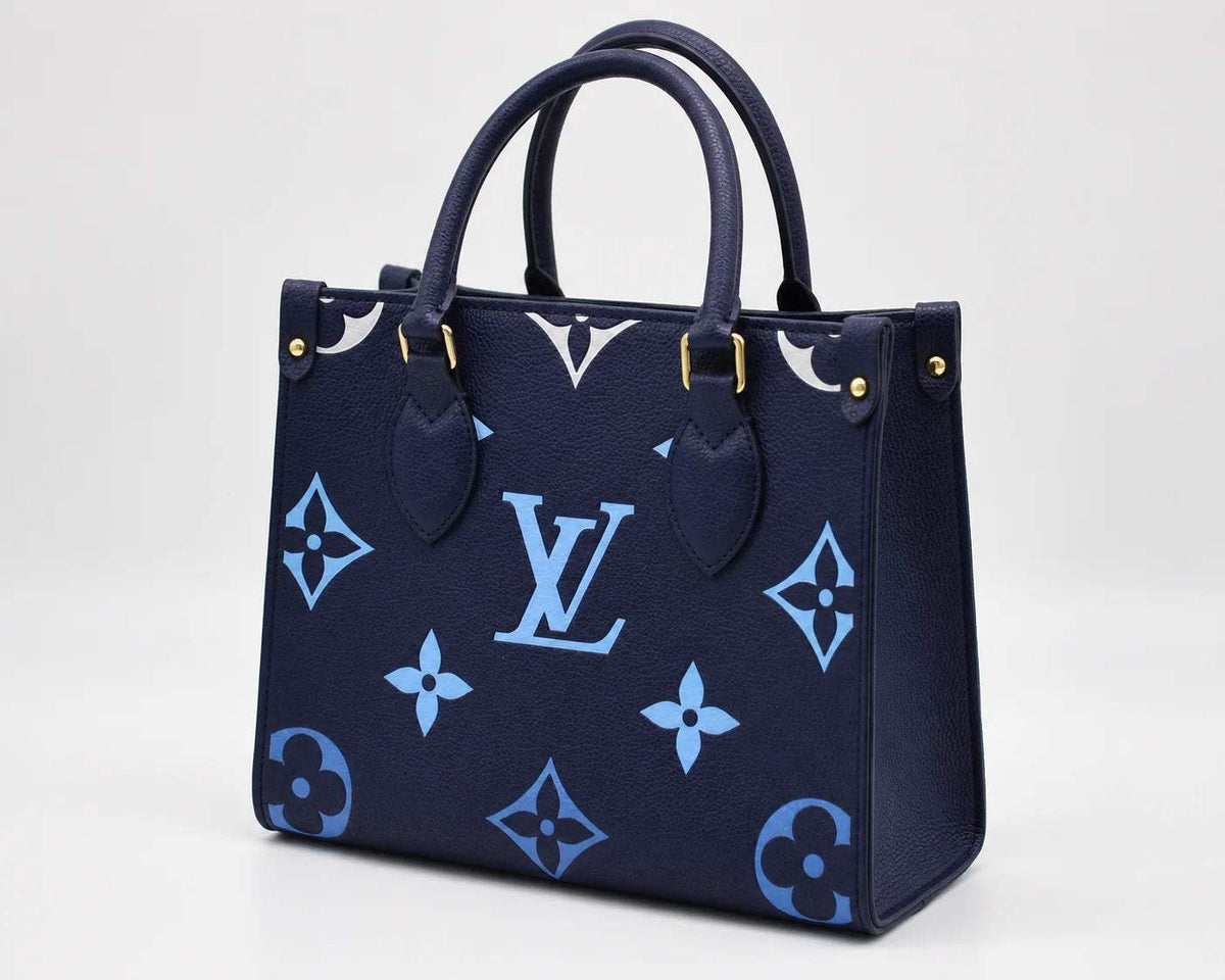 Navy blue luxury leather handbag with light blue monogram patterns and gold-tone hardware
