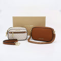 Two Michael Kors crossbody bags in logo print and brown leather with a gift box.