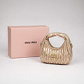 Gold quilted Miu Miu shoulder bag with matching pink gift box