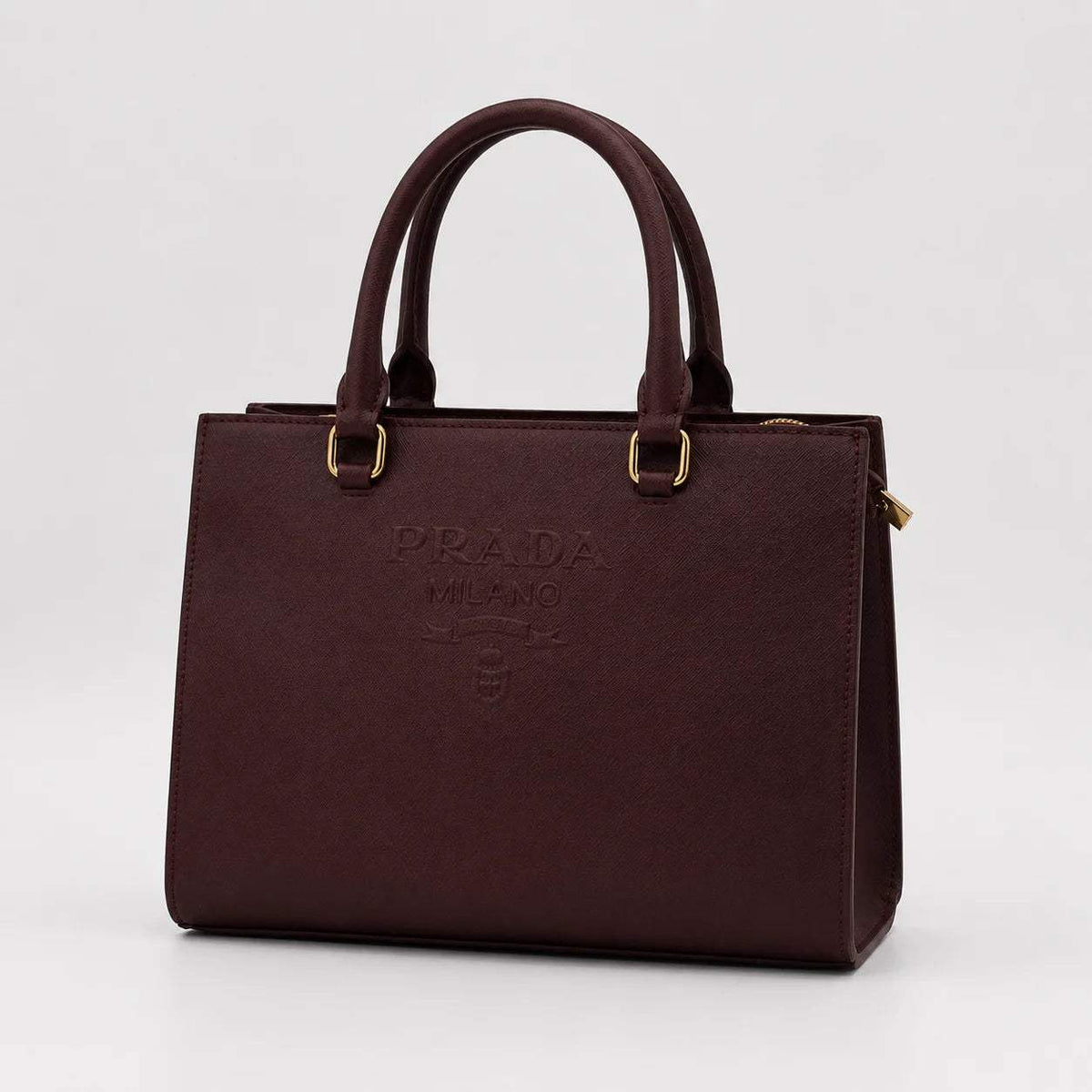 Burgundy Prada Milano luxury leather handbag with top handles against a white background